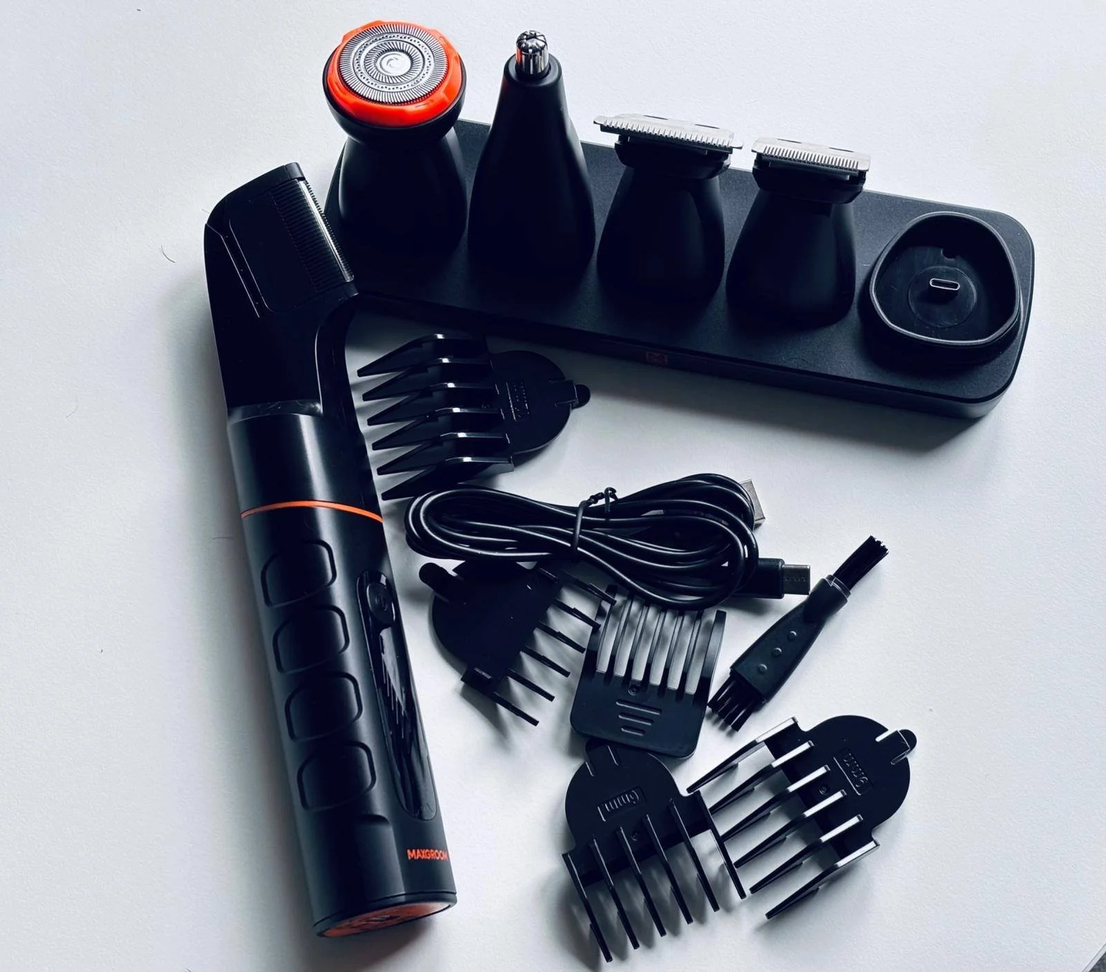 What’s included in the Maxgroom body hair trimmer kit, including trimmer, charging stand, guide combs, cable, cleaning brush and multiple grooming attachments.