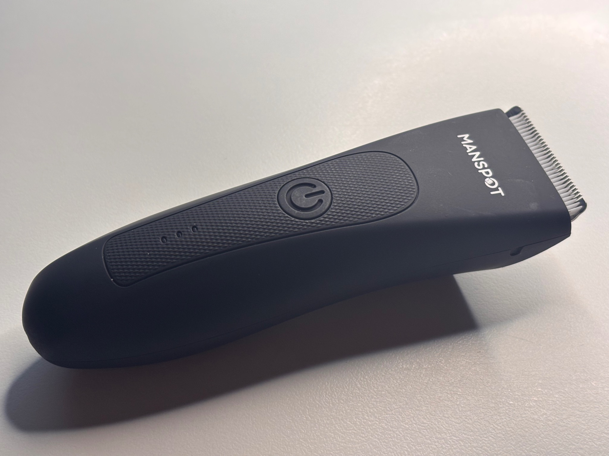 Close-up of the Manspot body hair trimmer design and power button