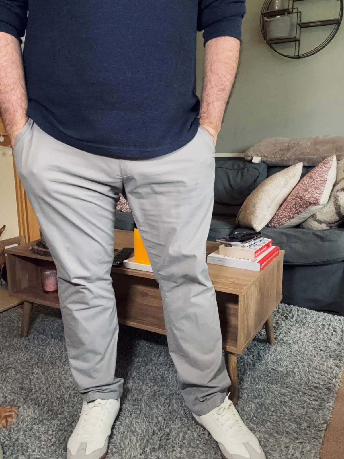 Jerome wearing Tailor Vintage light grey slim fit chinos with white trainers in a relaxed smart-casual outfit at home.