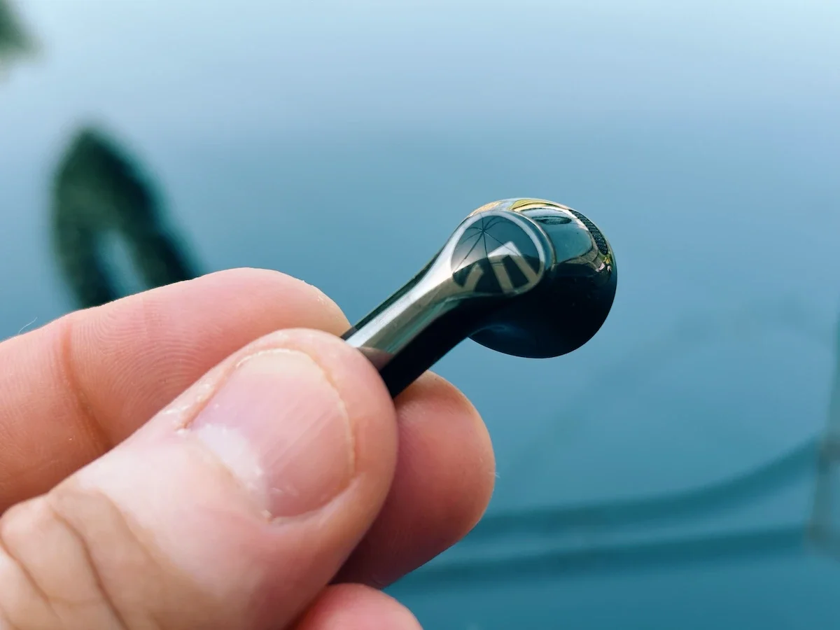 Close-up of one SoundPEATS Air6 HS earbud showing the glossy black and silver design with the SoundPEATS logo.