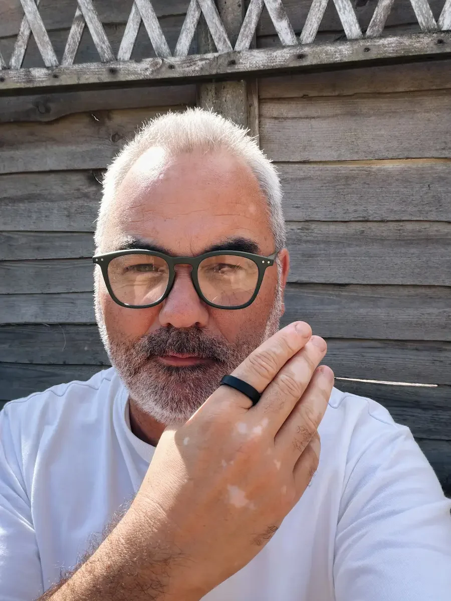 Jerome wearing the Matte Black RingConn Gen 3 smart ring while sitting outdoors.