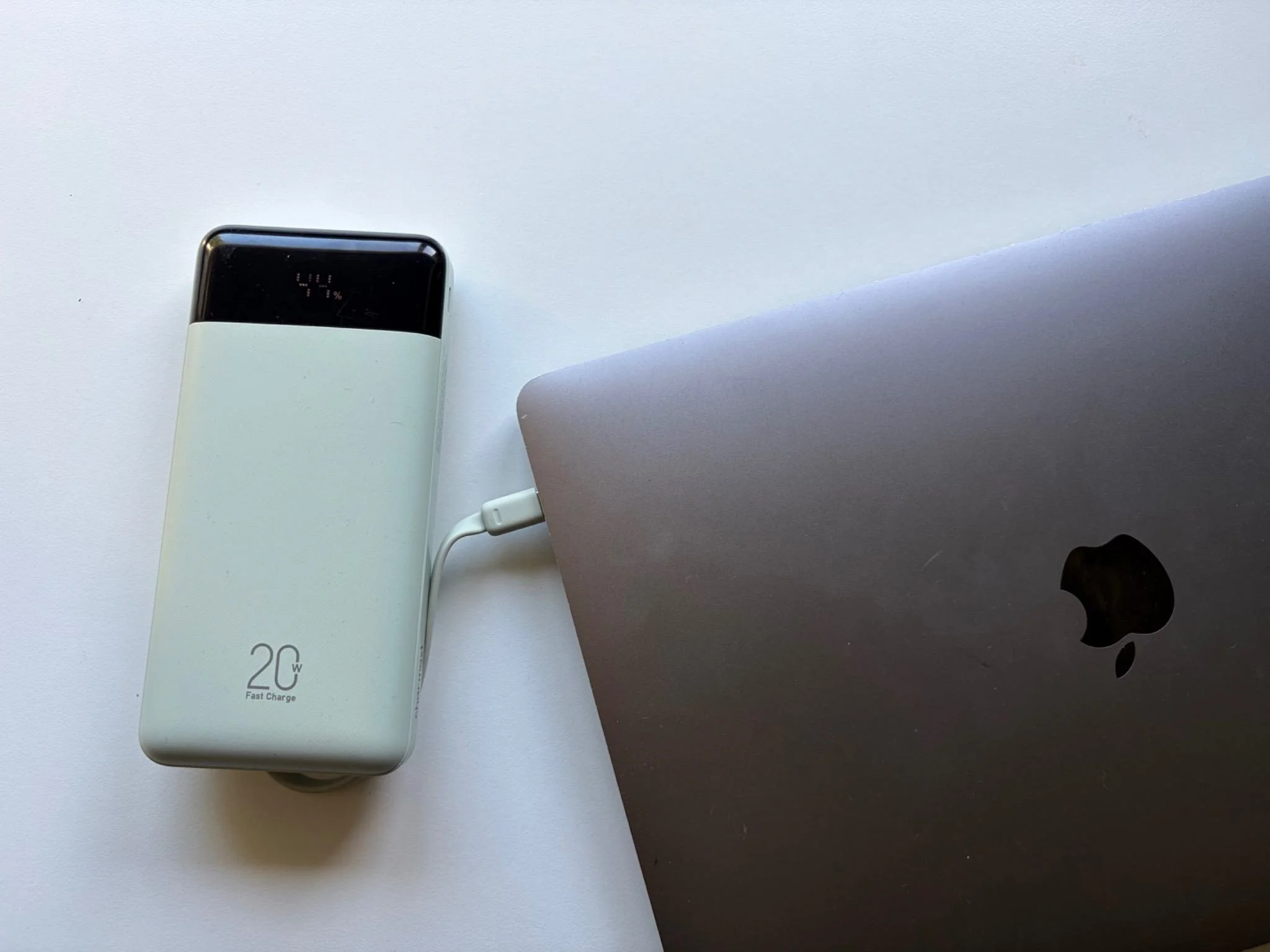 Charmast 20000mAh power bank connected to a MacBook Air with its built-in USB-C charging cable.
