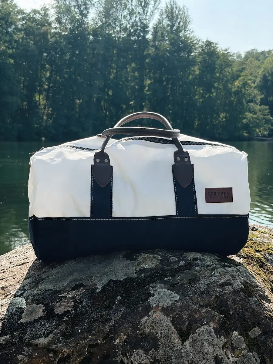 Full front view of the Sea Bags Chebeague Duffel with white sailcloth and navy canvas base