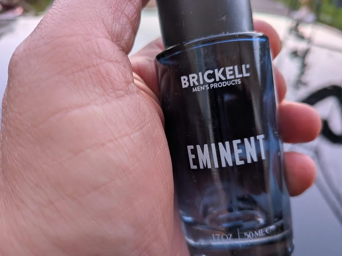 Jerome holding a bottle of Brickell Eminent men’s fragrance outdoors.