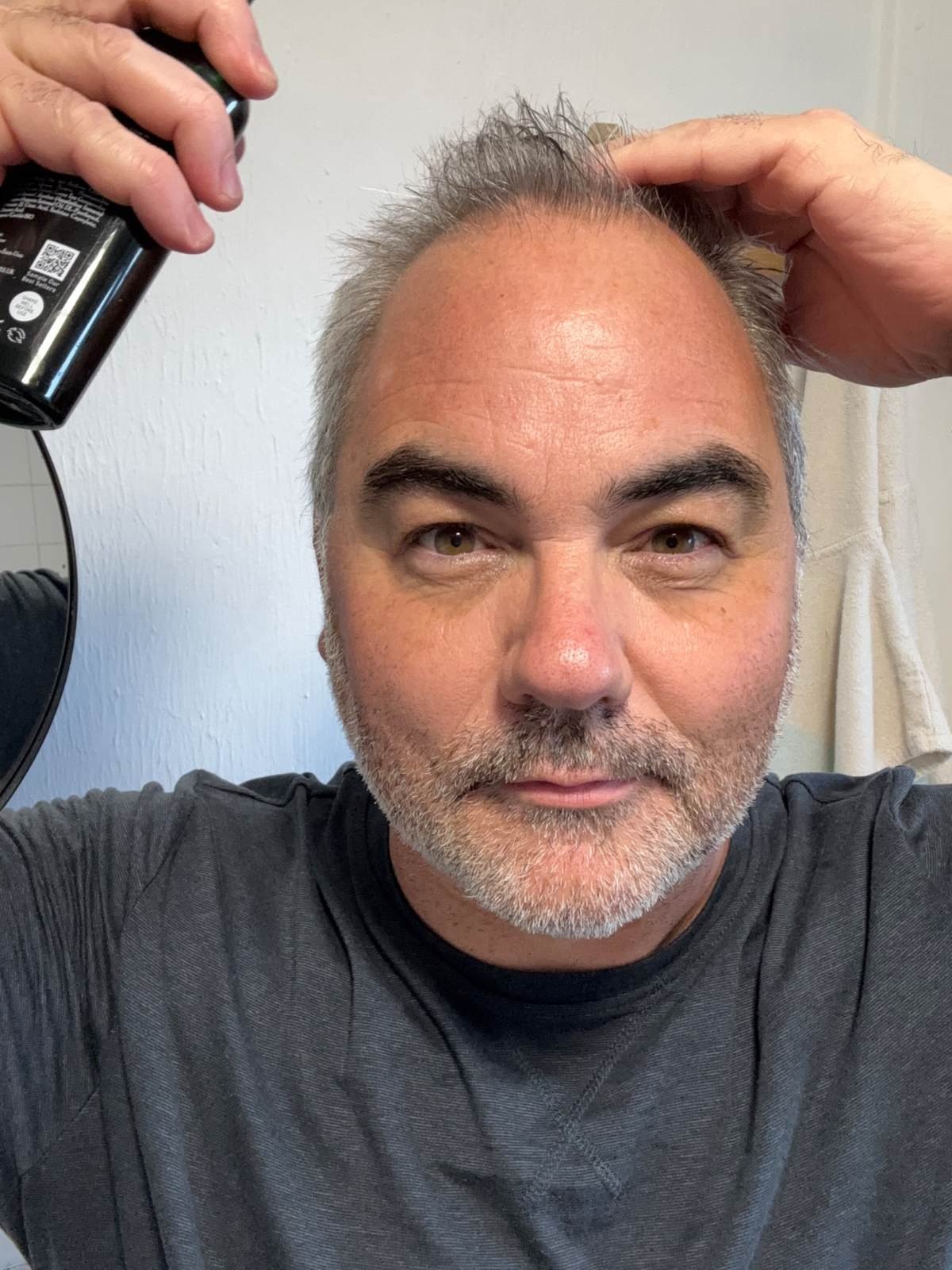 Jerome applying Brickell Sea Salt Spray to short thick hair.