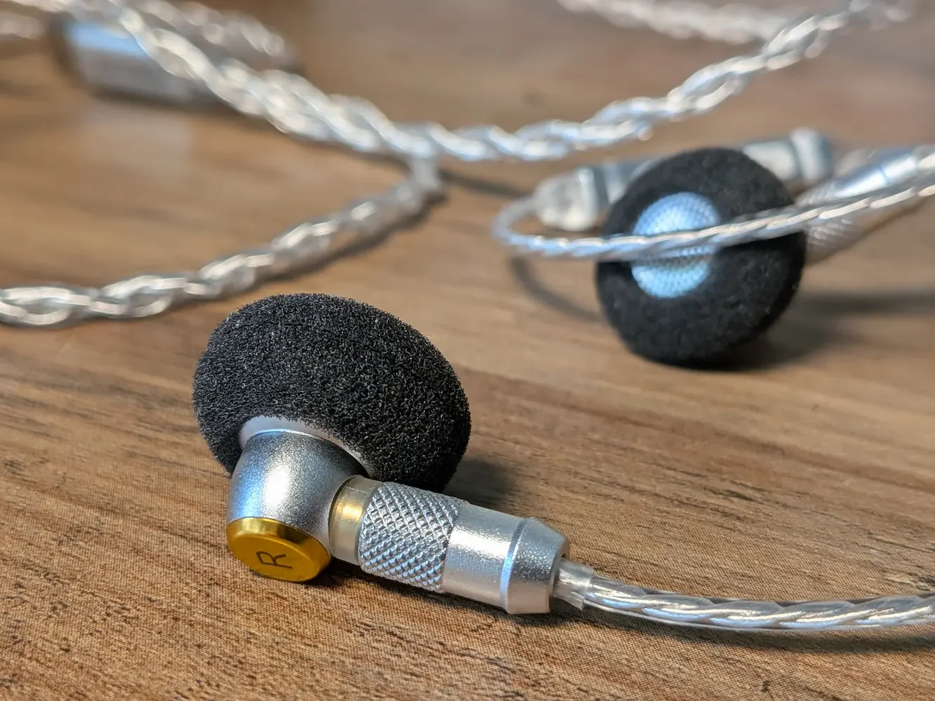 Close-up of the SIVGA M260 wired earphones with silver cable and black foam ear tips