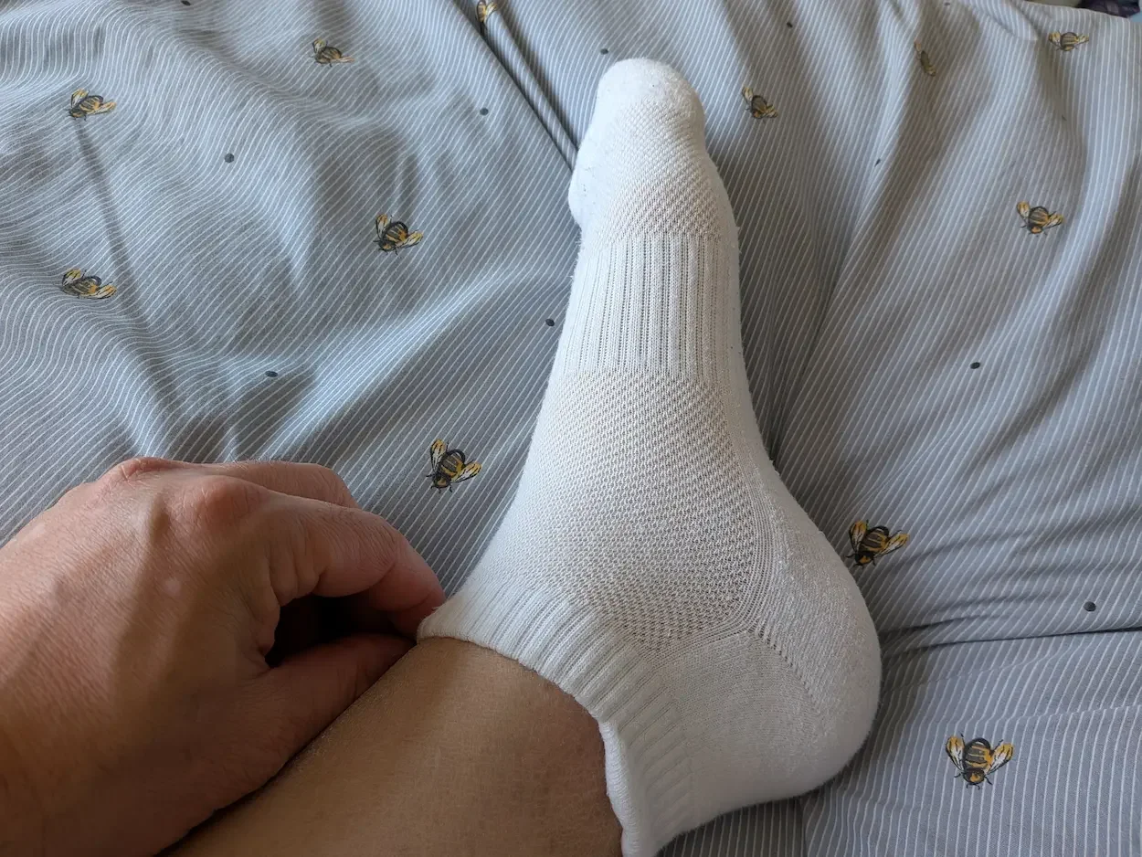 White Closemate ankle sock worn on foot showing the fit around the ankle and heel.