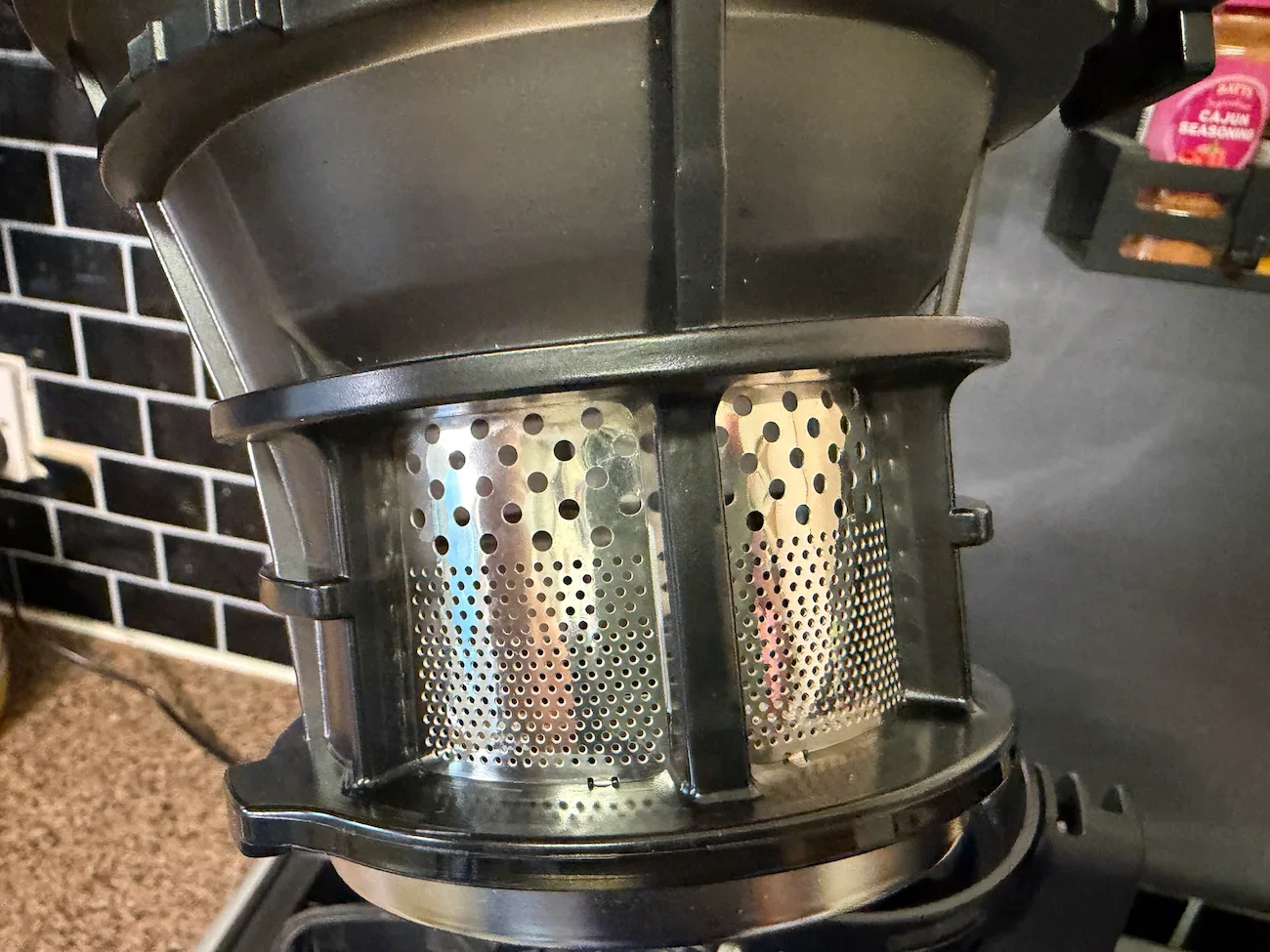 Close-up of the AMZCHEF cold press juicer's cylindrical metal filter showing its fine perforations.