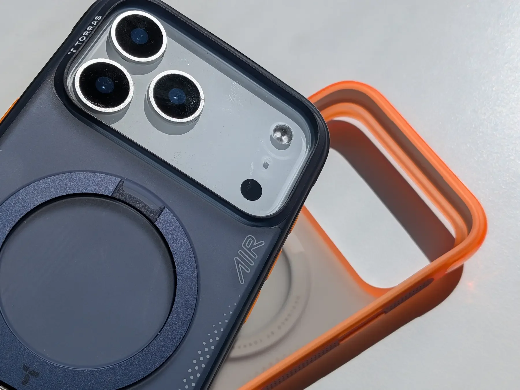 Close-up of the TORRAS Ostand Q3 Air case on the iPhone 17 Pro Max, showing the camera cutout, rear design and orange frame detail.