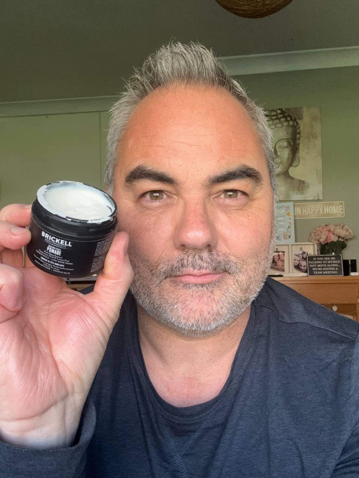 Jerome holding Brickell Shaping Paste Pomade, his favourite styling product for short thick hair.