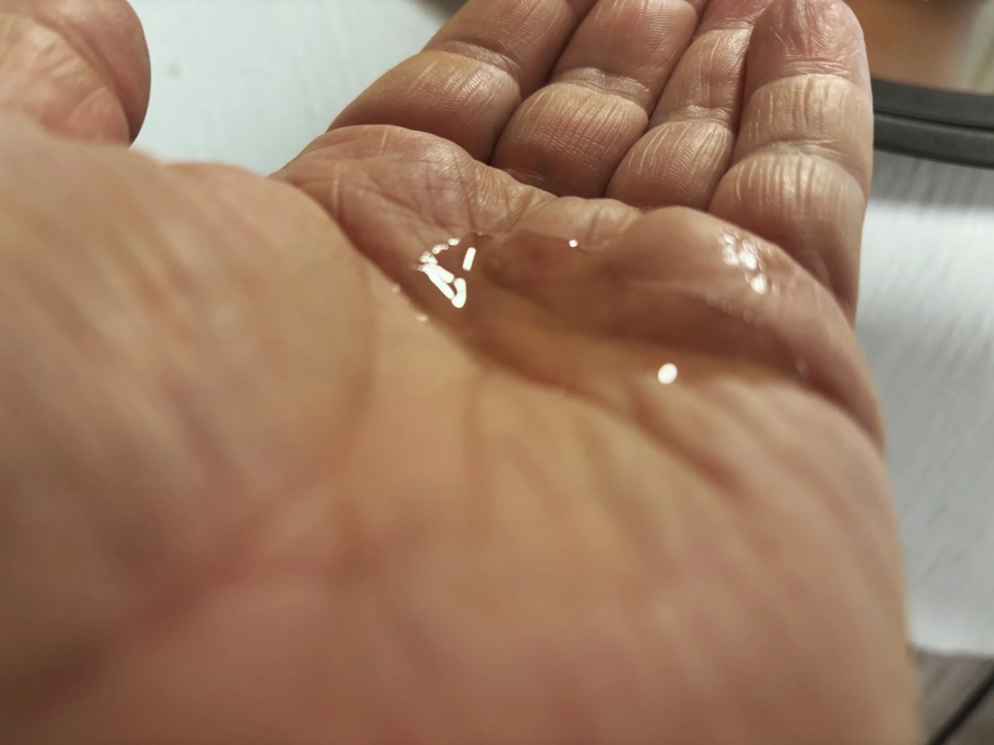 Texture of Man Labs Titan MAX Peptide Serum shown on the palm of a hand.
