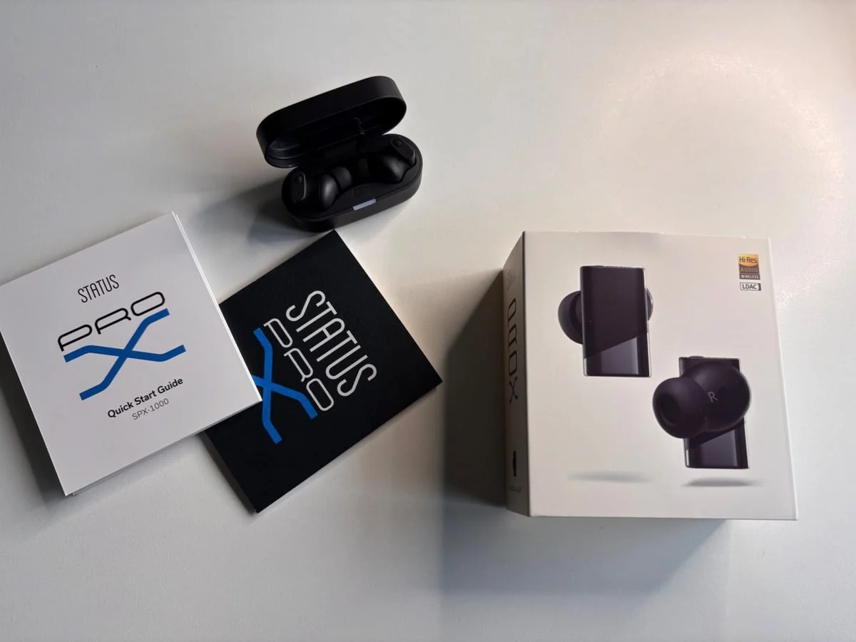 Status Pro X earbuds review showing charging case and retail box