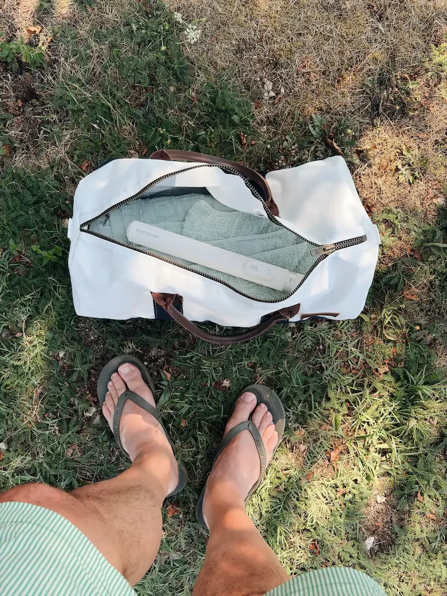 Open Sea Bags Chebeague Duffel containing a towel and pool essentials, viewed from above
