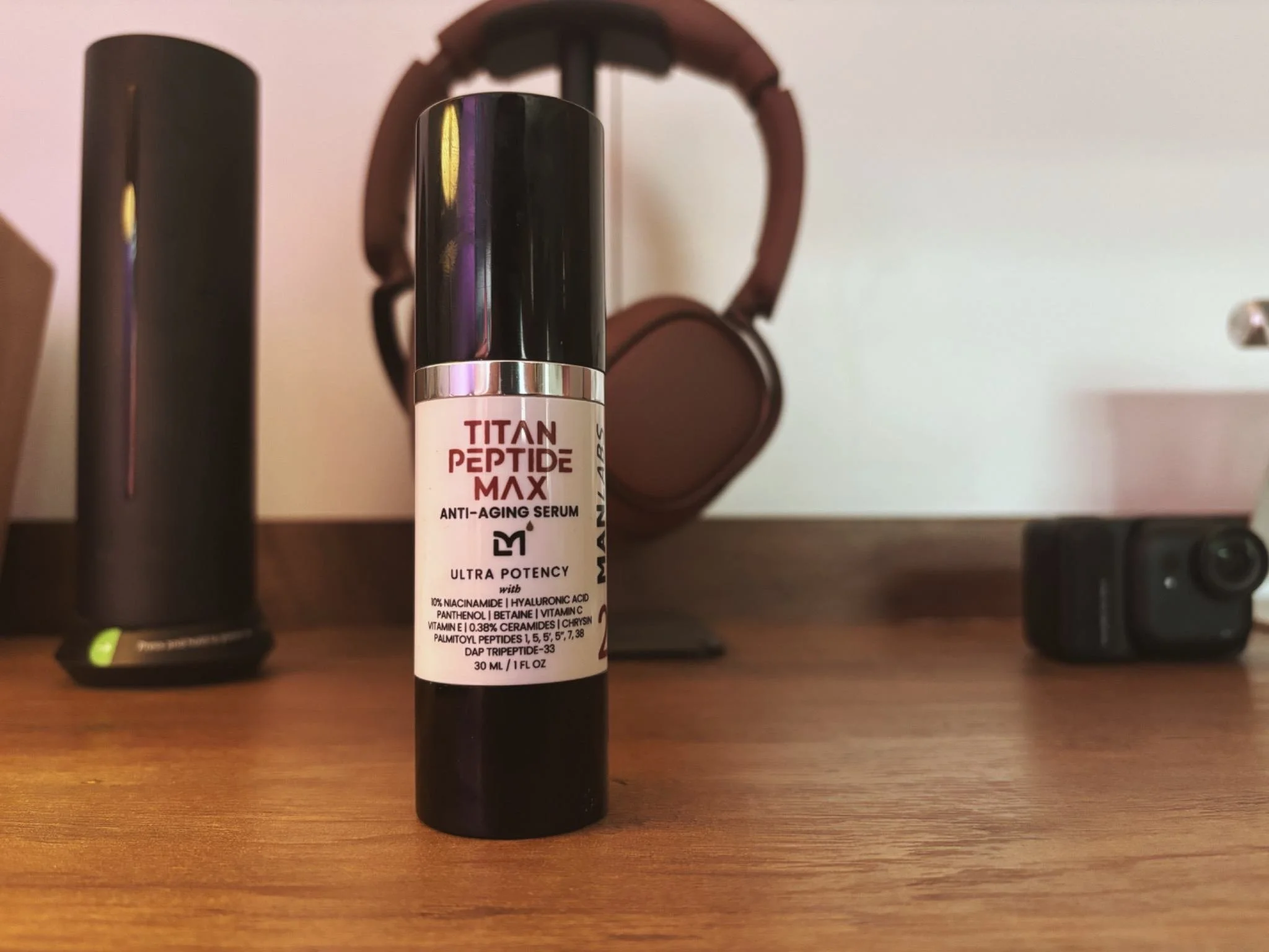 Man Labs Titan MAX Peptide Serum bottle standing on a desk (anti-aging serum).