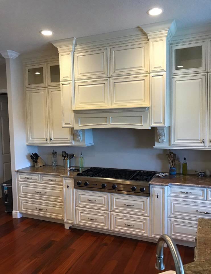 Kitchen with cream-colored cabinets, a built-in stove, and wooden countertops.