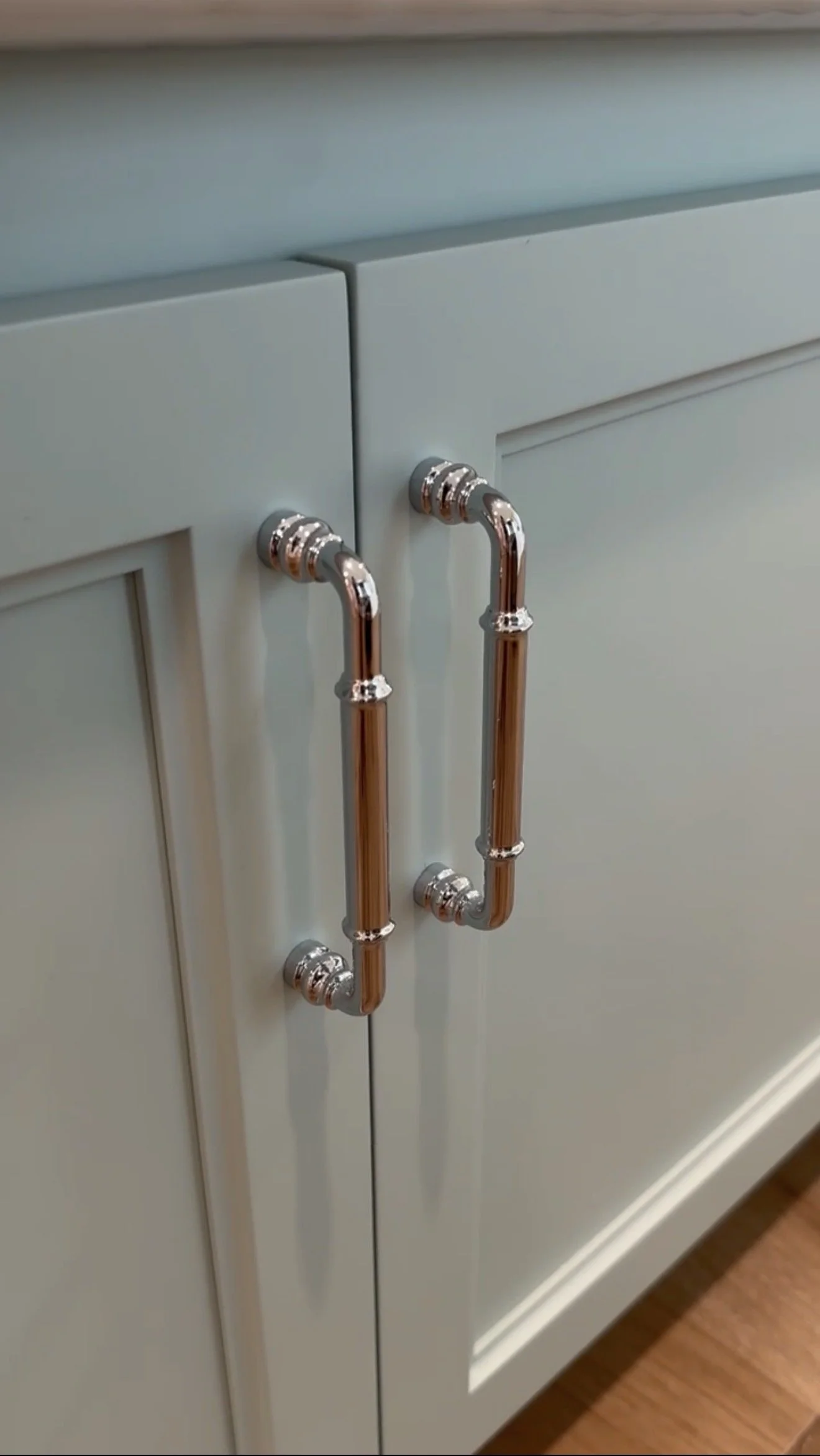 A kitchen cabinet with copper pipe handles.