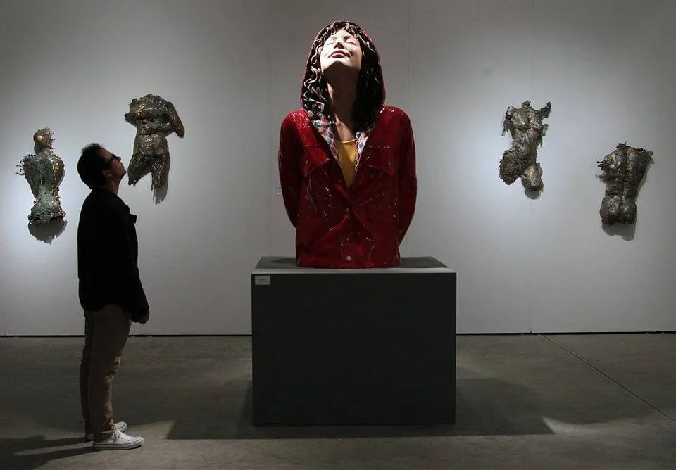 Carlos Lamas, looks up at Carole Feuerman's City Slicker at Art Miami as it opened its doors in Midtown.