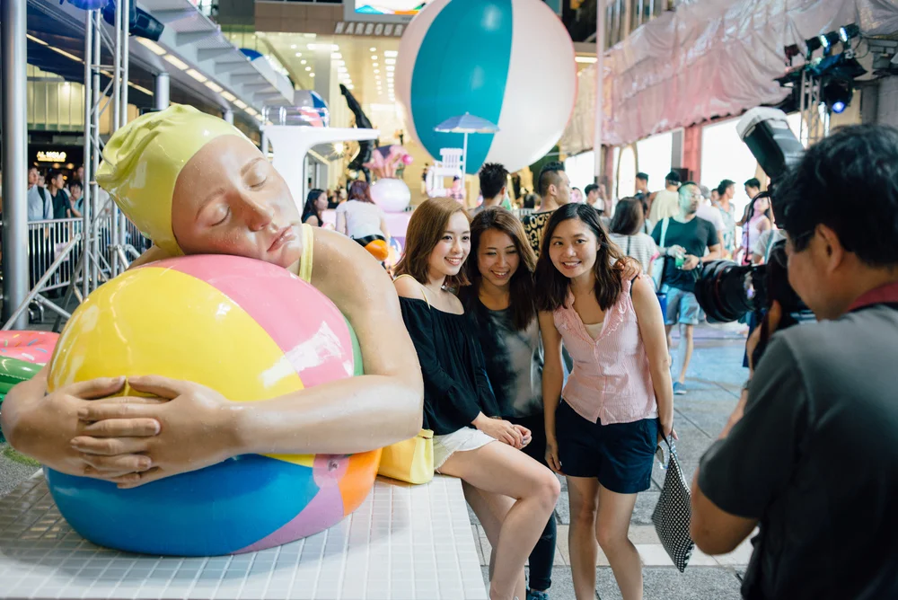 Fans pose by Feuerman's Brooke With Beach Ball during the poolside party celebrating the exhibition.