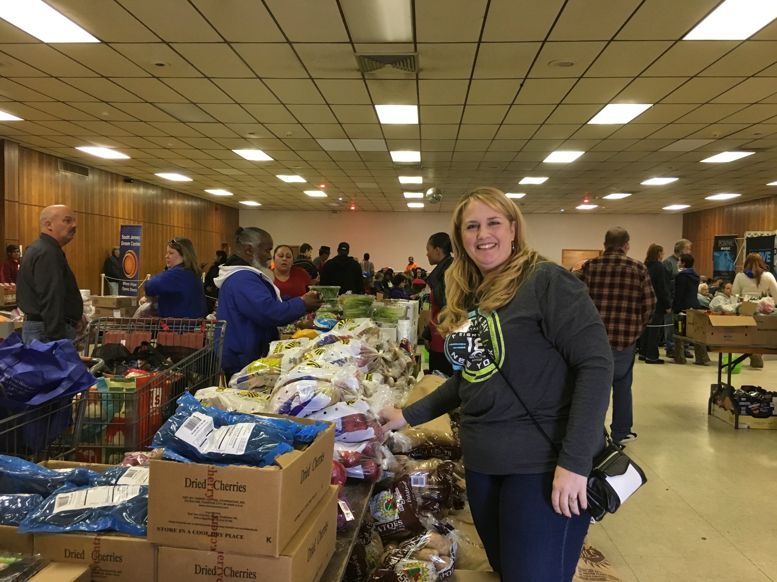 Volunteer Angela Horn-Worrell of Johnson Matthey assists guests with bags of fresh-picked fall fruit and vegetables from New Jersey Farmers Against Hunger.