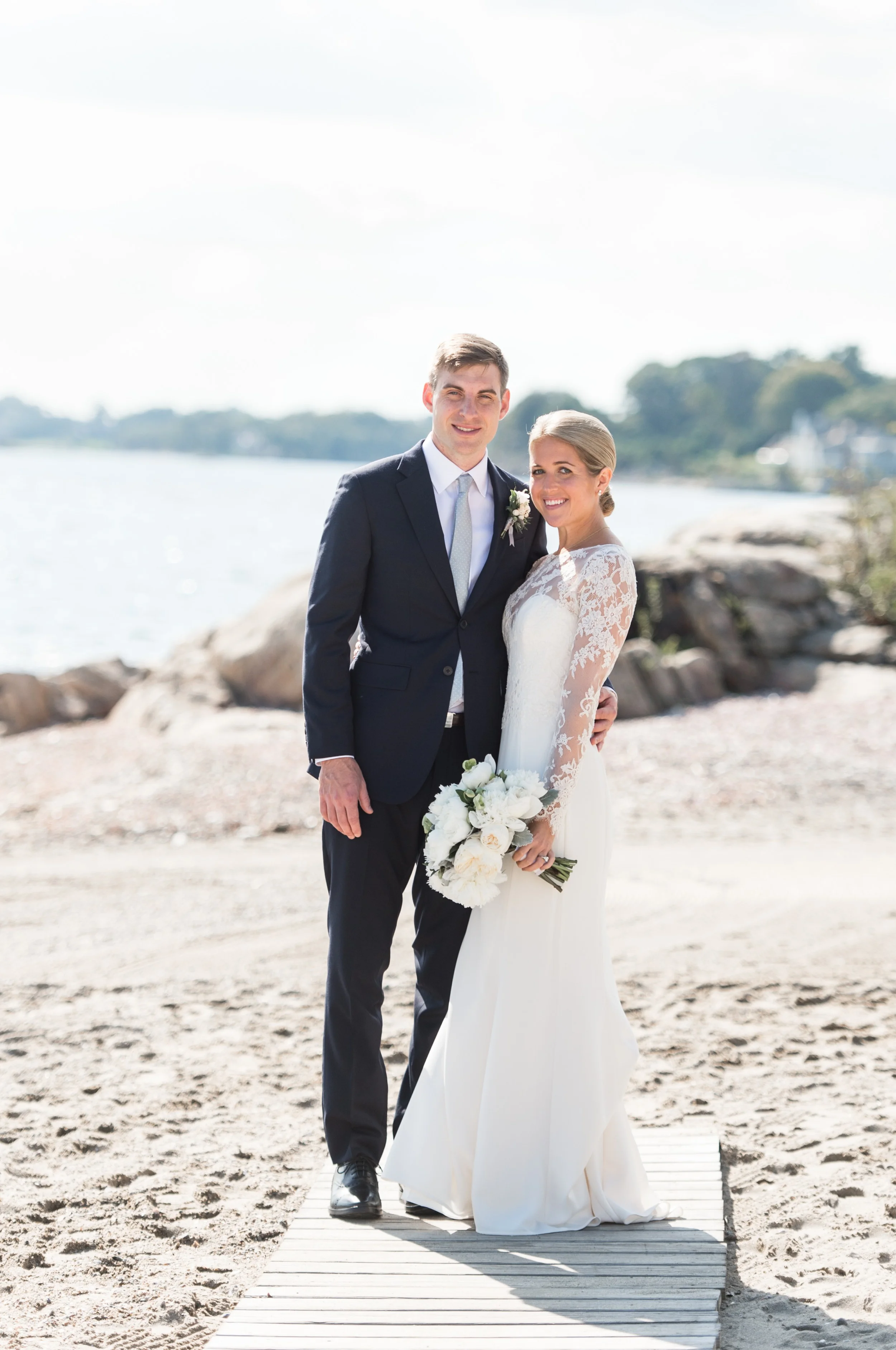 Wee Burn Beach Club Wedding Darien CT Bride and Groom Portraits on the Beach Lace Dress Navy Suit and White Florals