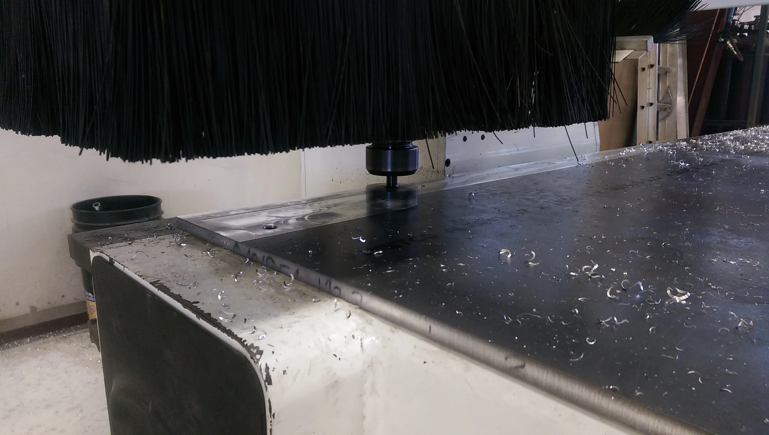 After bolting down a thick sheet of aluminum we put a 3" face mill in the machine and planed the sheet flat. Being able to do this operation right on the machine means the machine will be perfectly square to itself.