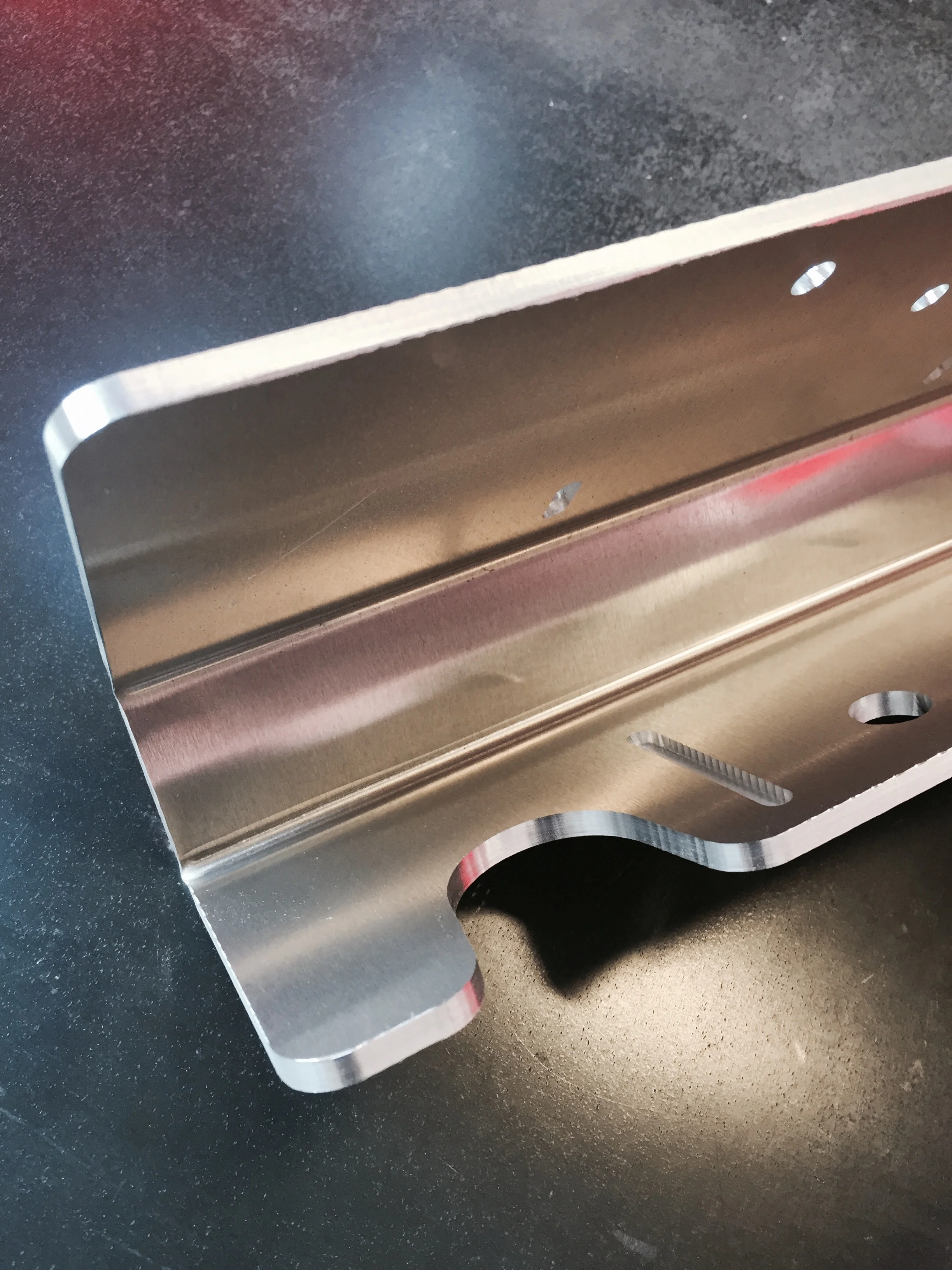 This is the base part of an aluminum assembly that is robotically welded together. The half-depth slot is a way to index the gussets that will be welded in without using an additional jig or measuring and tack welding each one in. As a side note, the finished edge quality is excellent on the Onsrud CNC router.
