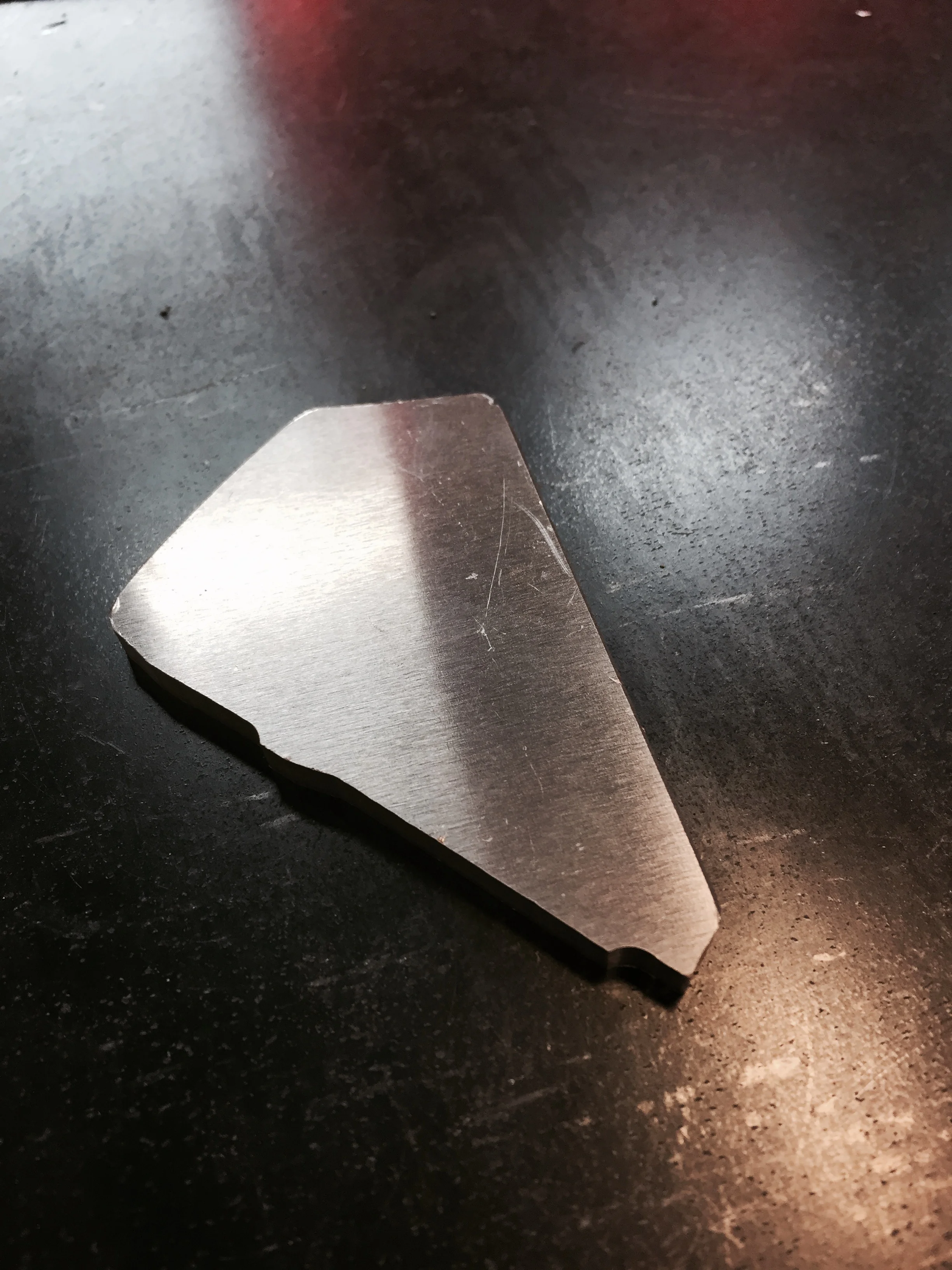 The gusset is a 3/16" thick 5052 aluminum part that is also cut on the CNC Router. The little tab sticking down seems like it is cut on an odd angle; however, much thought was put into the shape of it. The Robot Cell Operator can easily slide each gusset into place, but they will not fall out when the entire assembly rotates in the robotic jig.