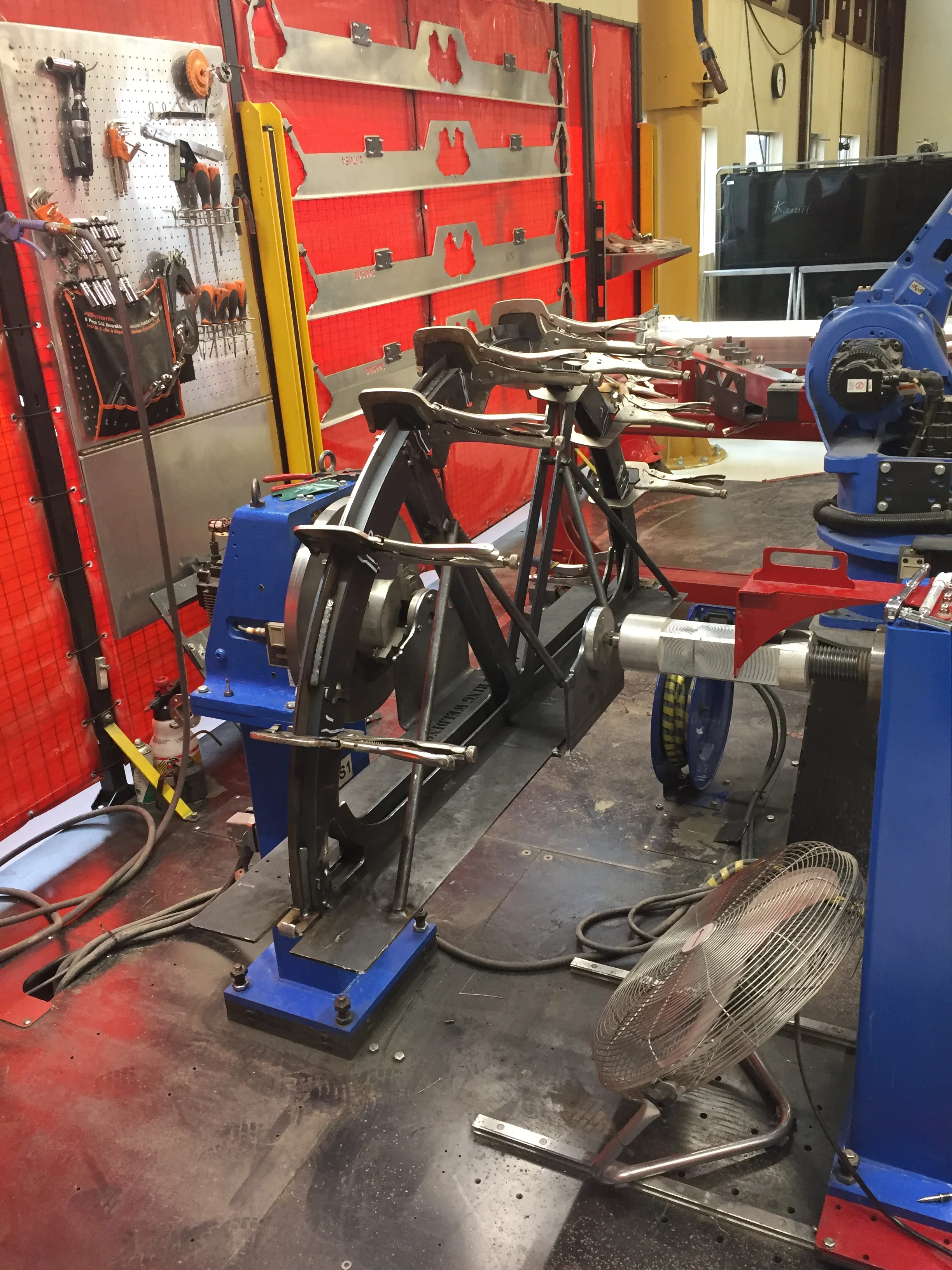 Step 1- Design and build a jig assembly that can make part placement repetitive and accurate. We've used the Motoman positioner in conjunction with the robot to help keep weld angles consistent. Consistent weld angles give us good flux gas (CO2/Argon mix) coverage to make sure welds are not contaminated with atmospheric impurities. 