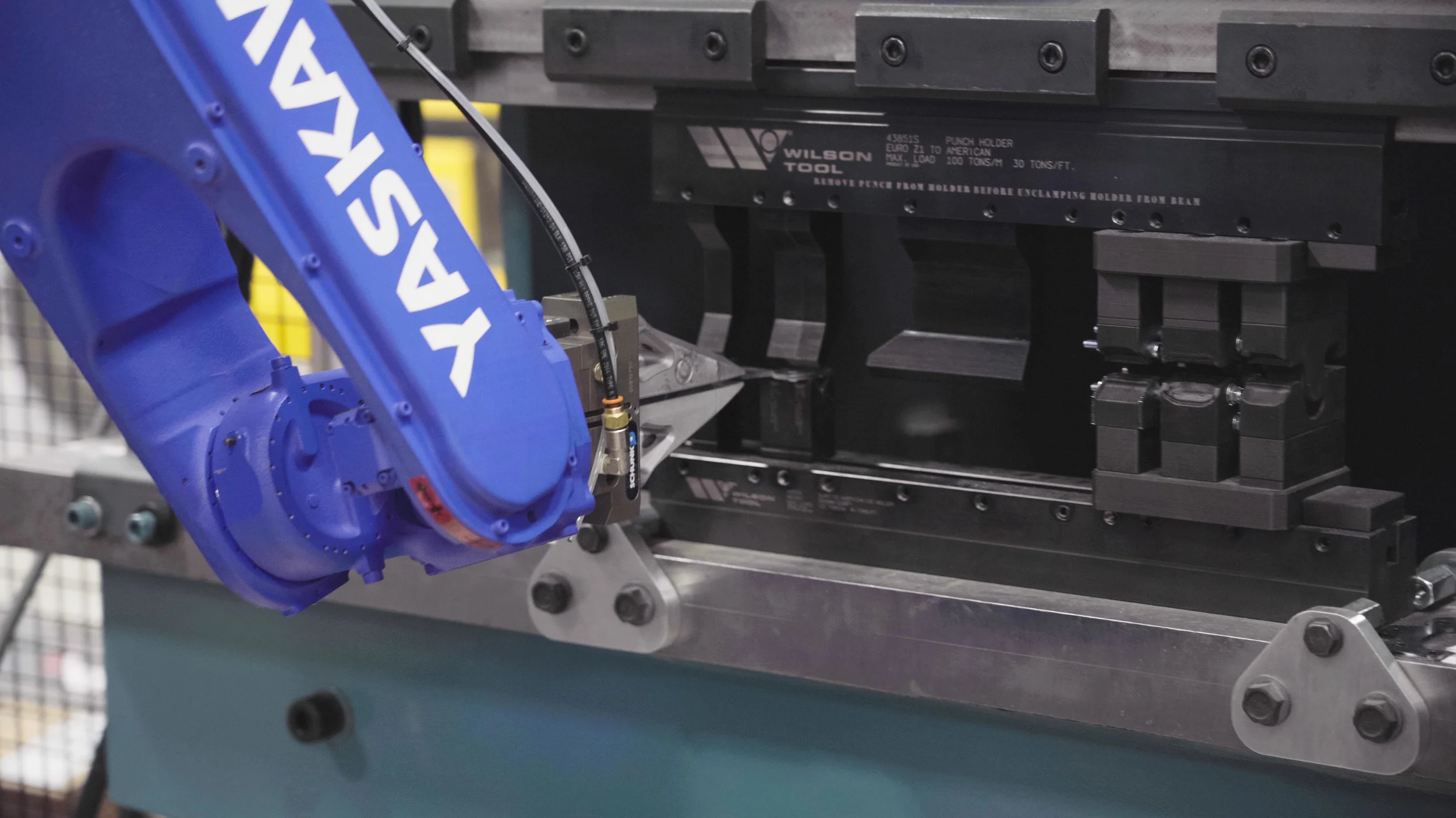 The robot is putting a part into the punch and die set for bending. The Wilson tooling is made at an angle that bending past 90 degrees is possible without changing to “stamping” in the tools.