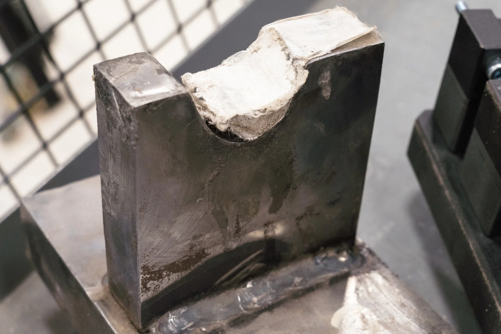An example of an old steel die (with white protecting tape applied) for a specialty aluminum clip that we produce. This die would last 5000 parts before having to be re-machined into the proper size.