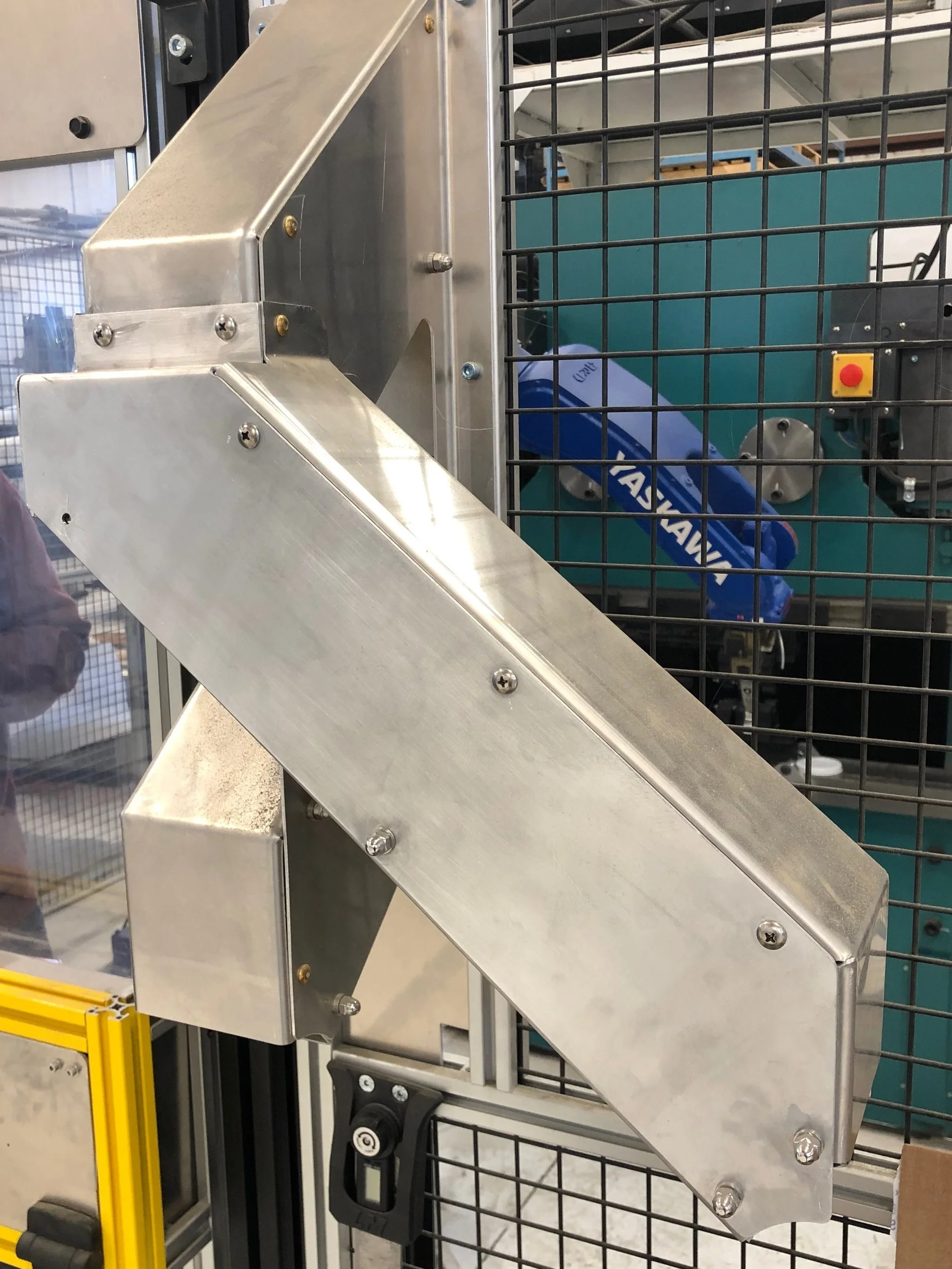 A sheet metal chute loads out into two different part bins.
