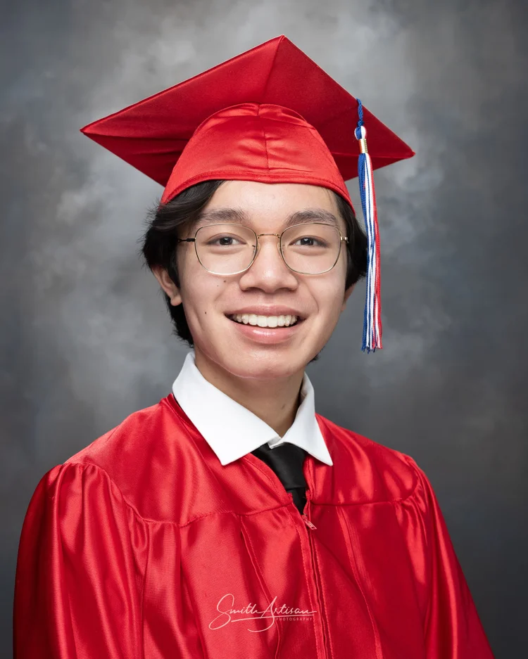 Senior yearbook portrait in red cap and gown with glasses
