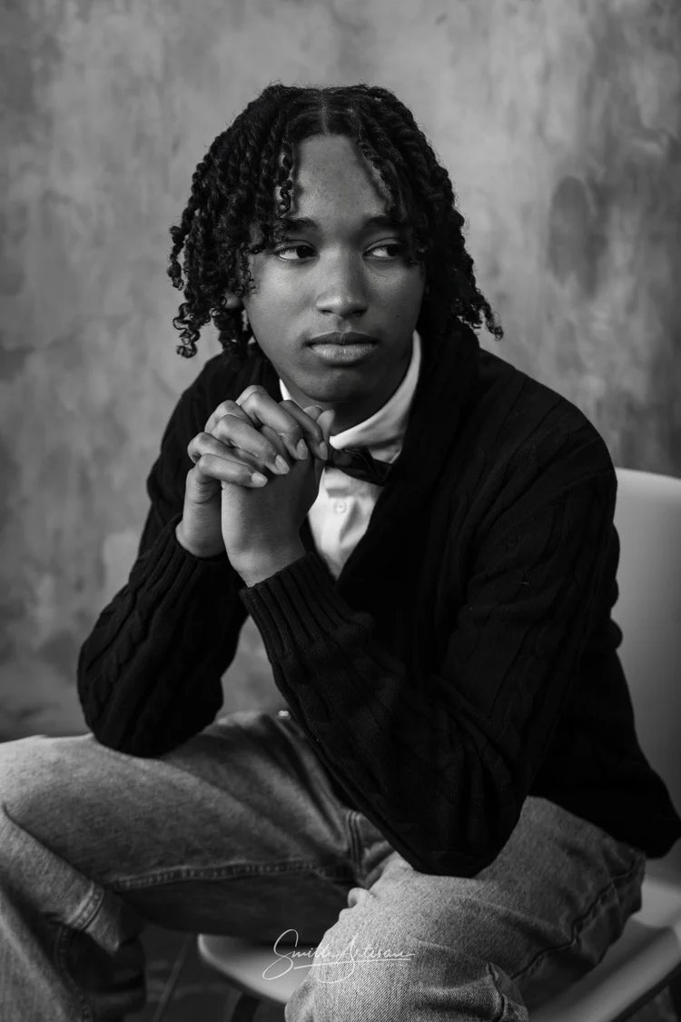 Black and white senior yearbook portrait in a cardigan and bow tie