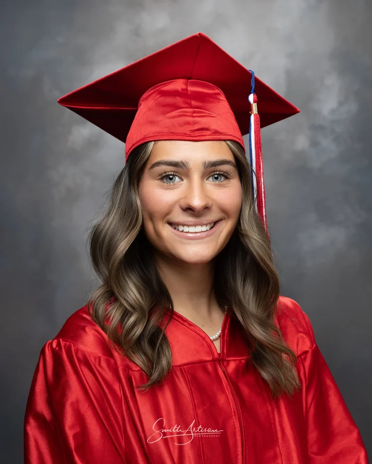 Senior yearbook portrait in red cap and gown