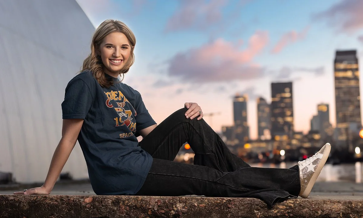 High school senior girl photographed with the downtown Memphis skyline for Memphis-area senior portraits by Smith Artisan