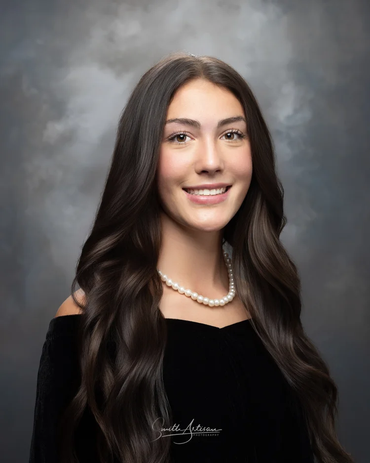 Senior yearbook portrait with pearl necklace and studio backdrop