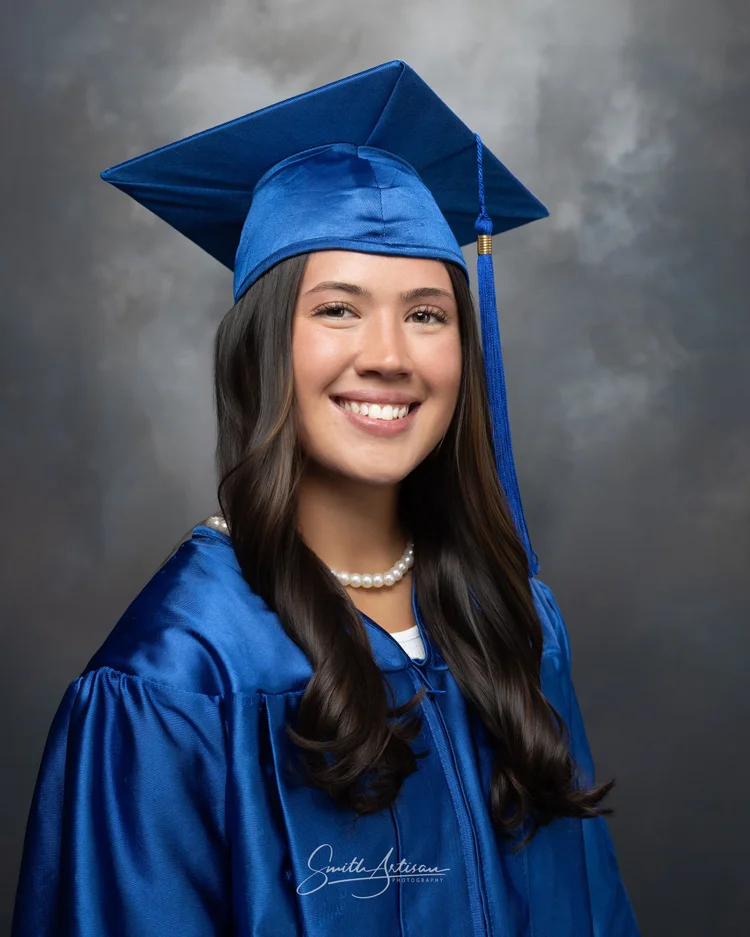 Senior yearbook portrait in blue cap and gown