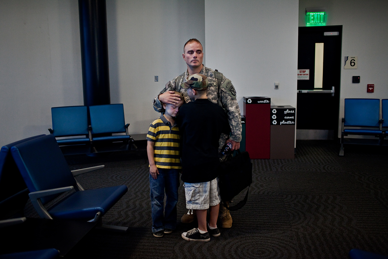  As the departure gate empties out into the boarding plane, Sergeant First Class Brian Eisch says goodbye to both his sons with a quiet embrace. 
