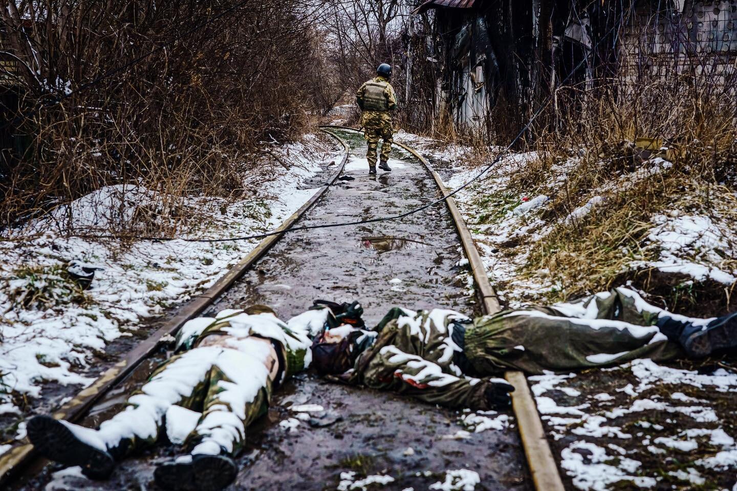 DISPATCHES: Day Six. Dead soldiers. A destroyed bridge. An icy river. Battle scars linger. People fleeing their besieged town on foot. A man and a woman watches people leave but turns back. Ukraine town of Irpin on the front lines prepares to battle 