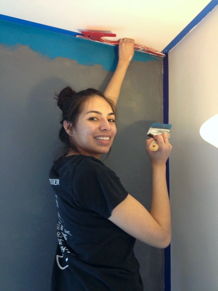  Using a paint shield, Joanna is able to block the blue paint from seeping under the tape and onto the bright white ceiling. 