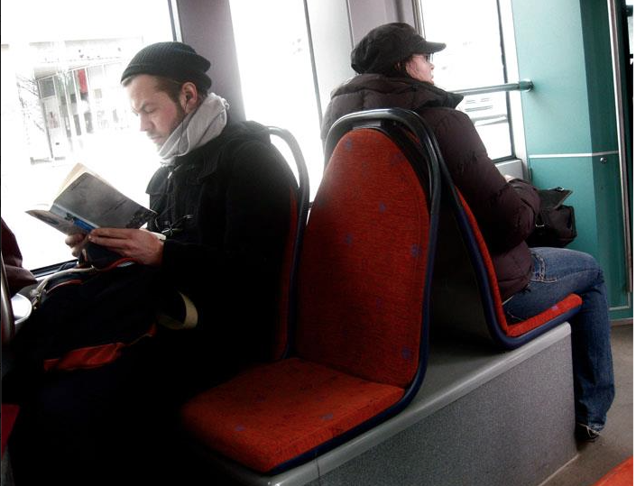   Young Man on Helsinki Tram reading, The Shape of a Pocket by John Berger.  