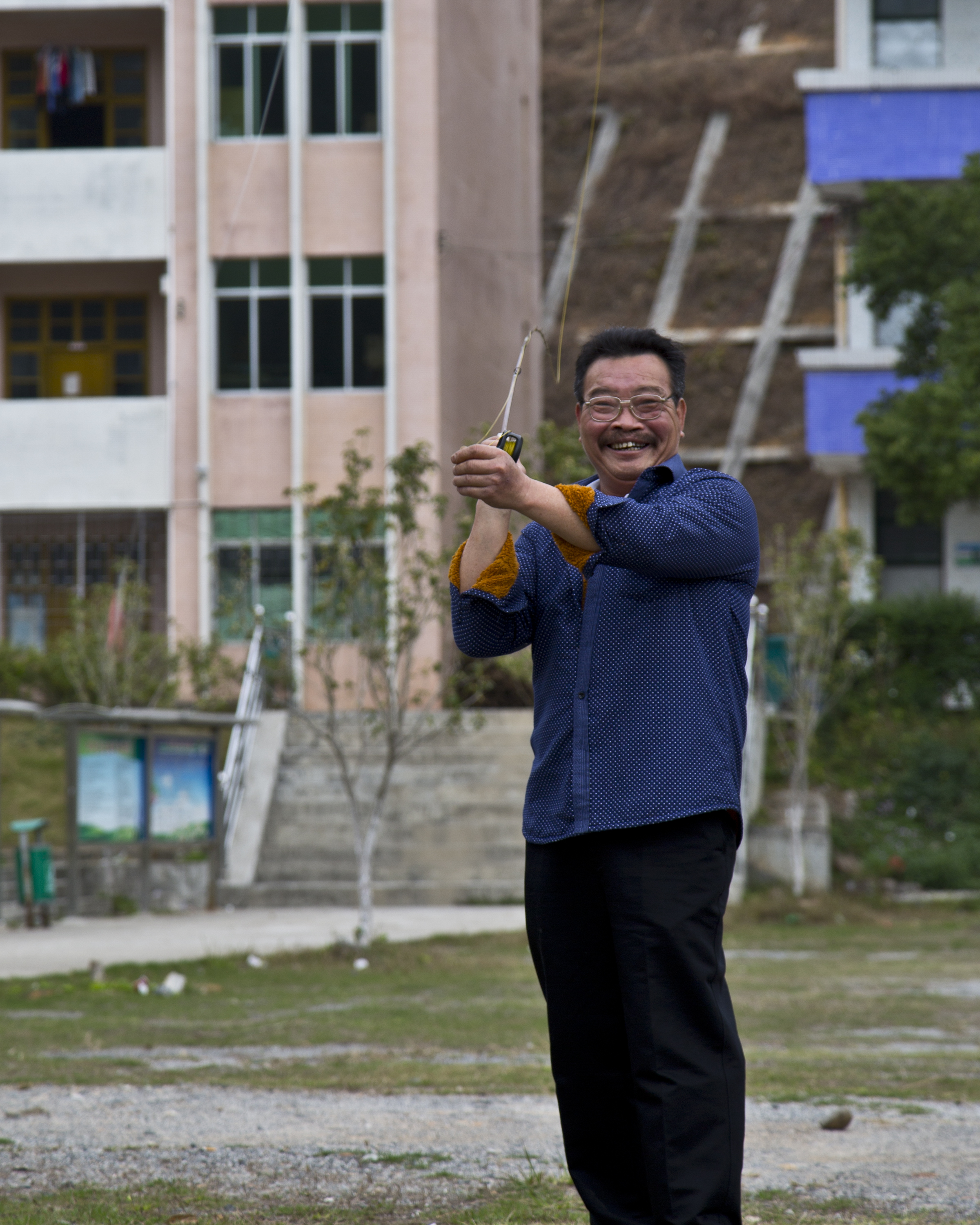 Lao Cai practicing the art of bamboo rod fly casting in the middle school playground across from his home.&nbsp;