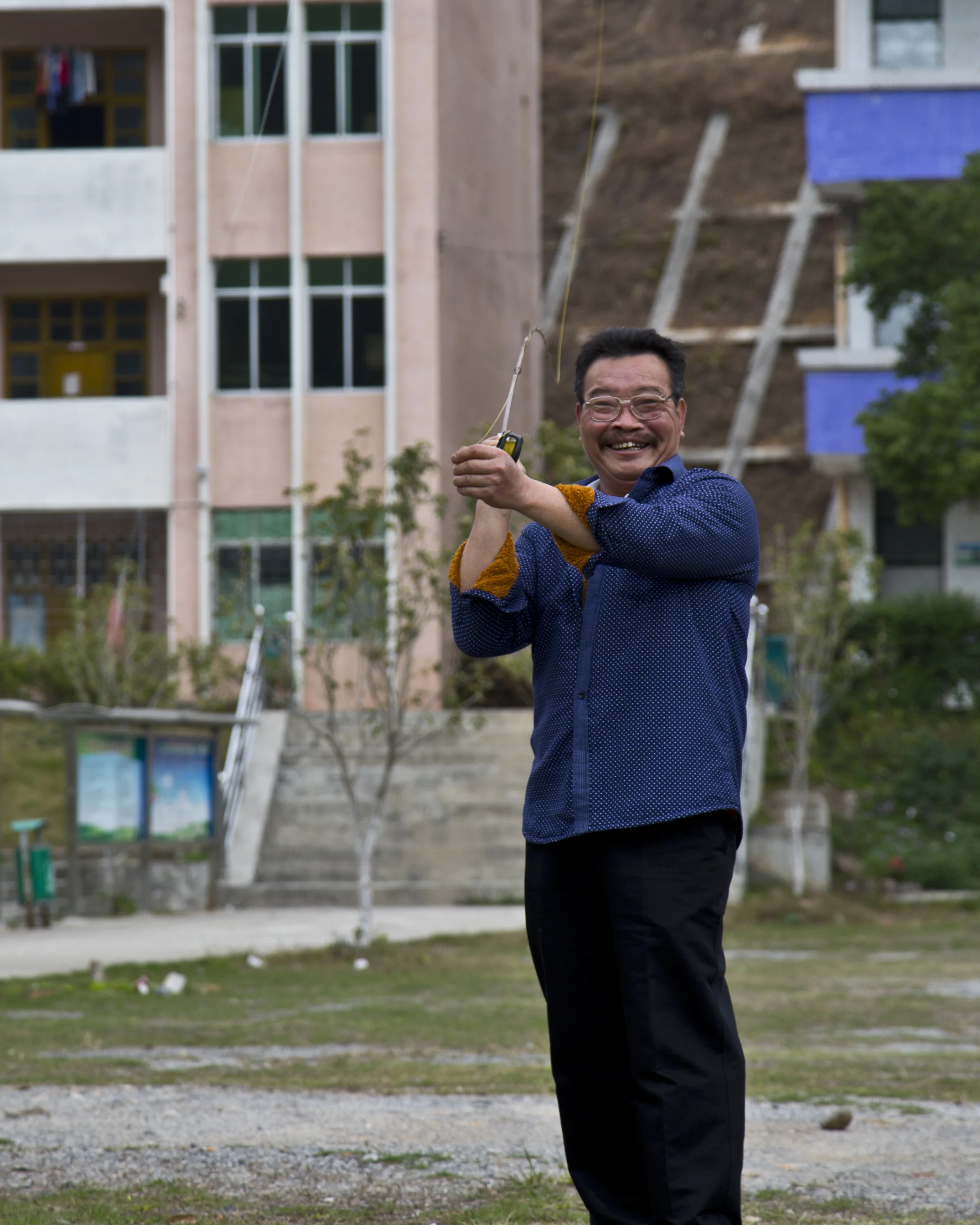 Lao Cai practicing the art of bamboo rod fly casting in the middle school playground across from his home. 