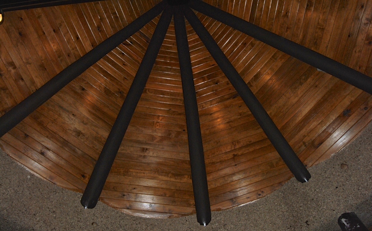 This is the view looking up into the gable end above the bure's front porch. They've added accent fixtures to highlight the beauty of the wood. I like the contrast between the tongue-and-groove, the beams, and the sand finish.