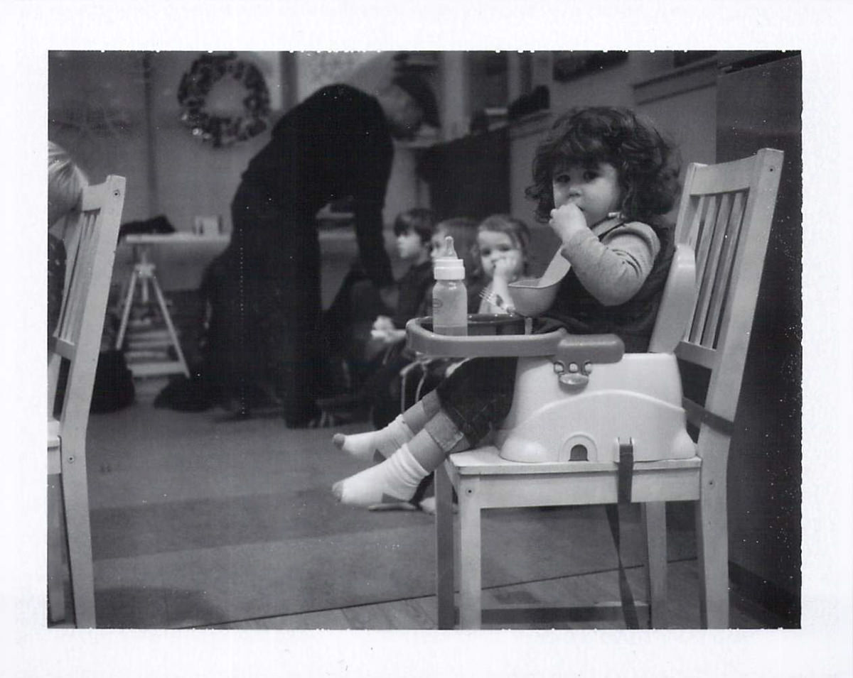 Baby Ivy eating dinner with our good friends the Starks in the background