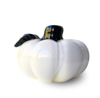 White pumpkin-shaped object with a black top and a decorative design resembling a witch's hat.