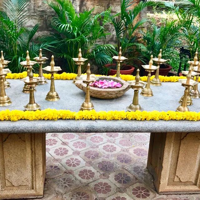 A stone table set with flowers and traditional brass oil lamps... #india #indianwedding #incredibleindia #southindianwedding #blooms #flowers