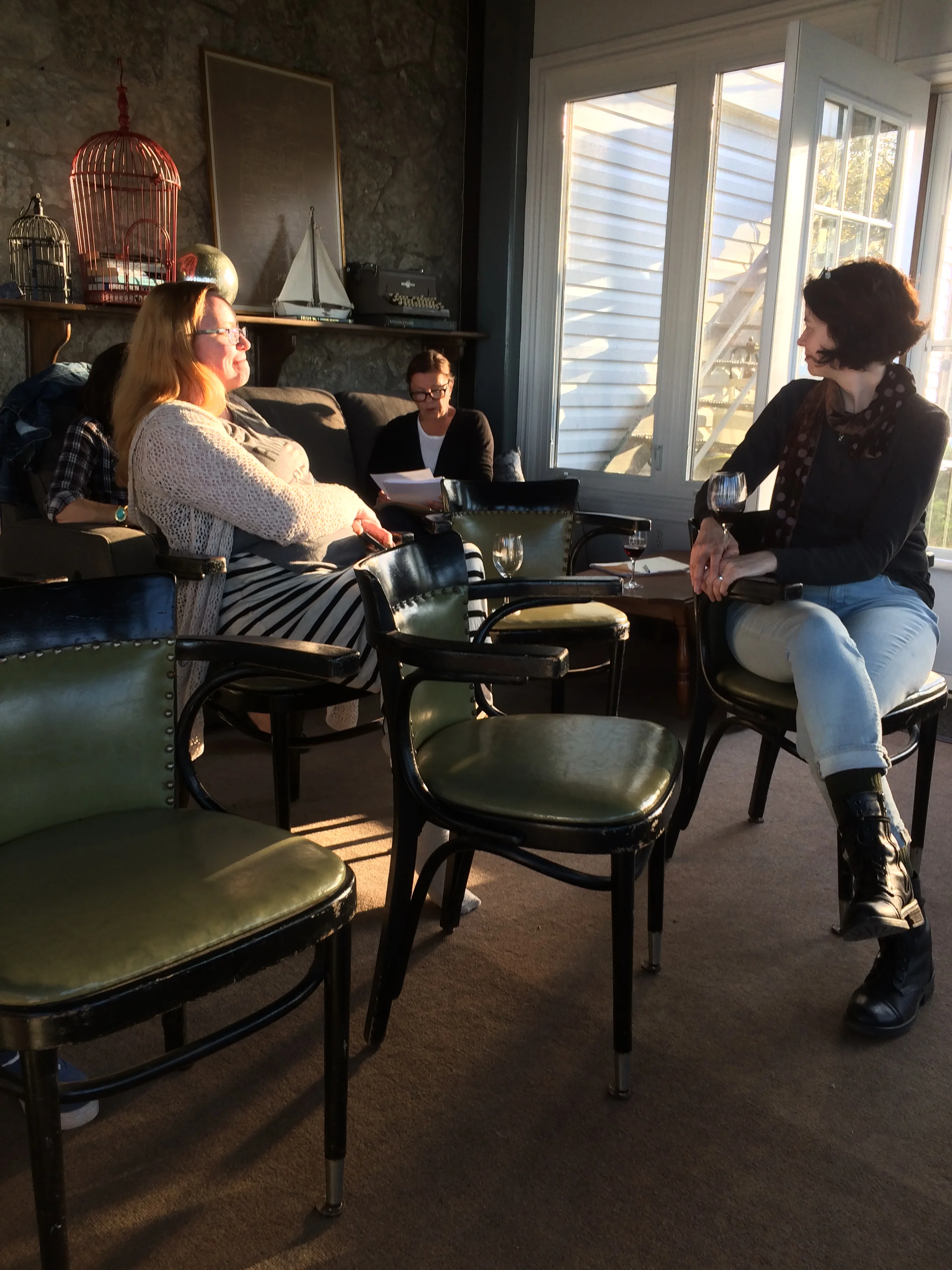 Writers Dawn Kresan & Alisa York listen to a reading from Diana Leszczynski at magic hour on Pelee Island