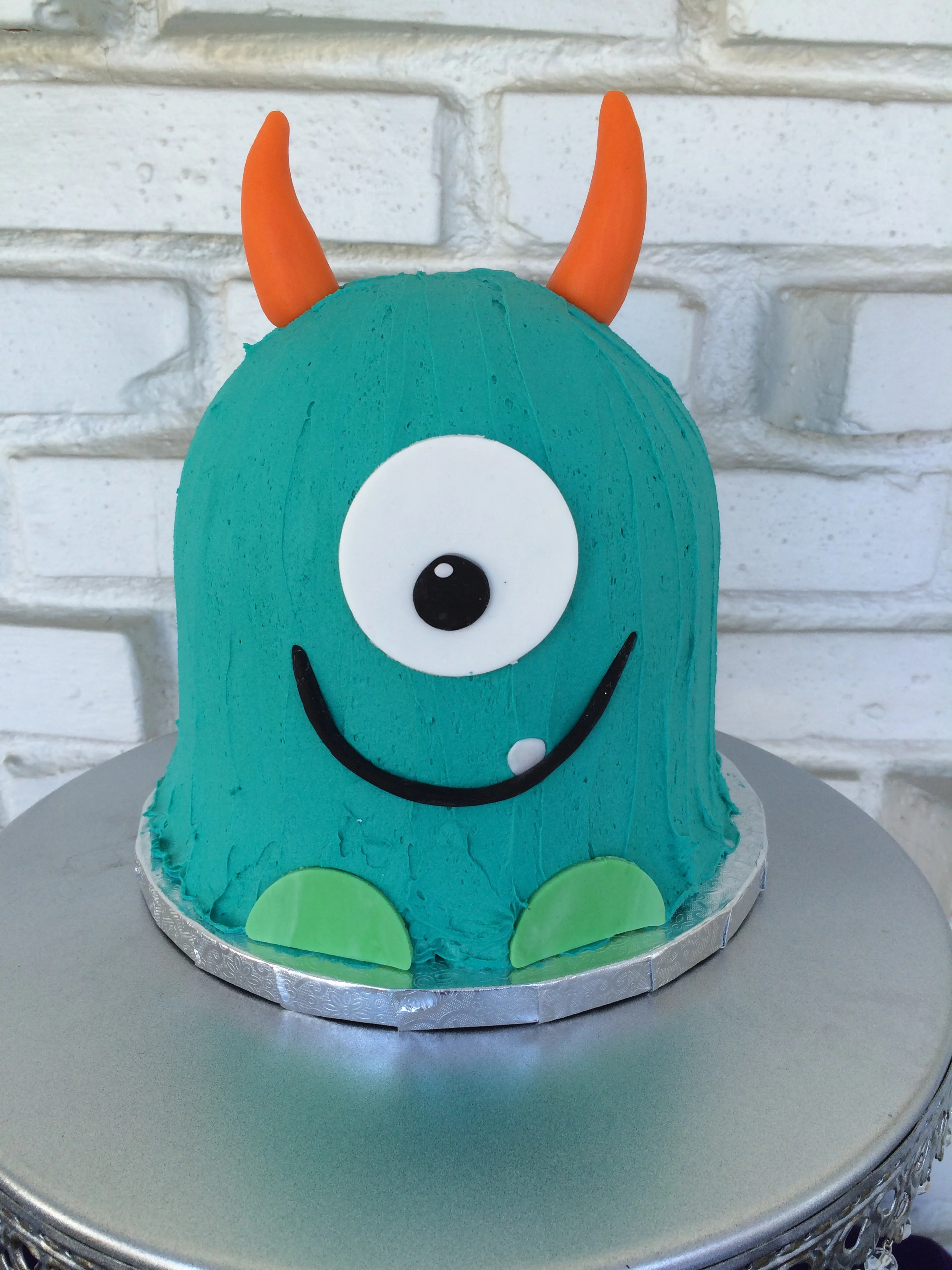 Lemon cake filled with lemon curd and topped with vanilla buttercream and fondant monster accents