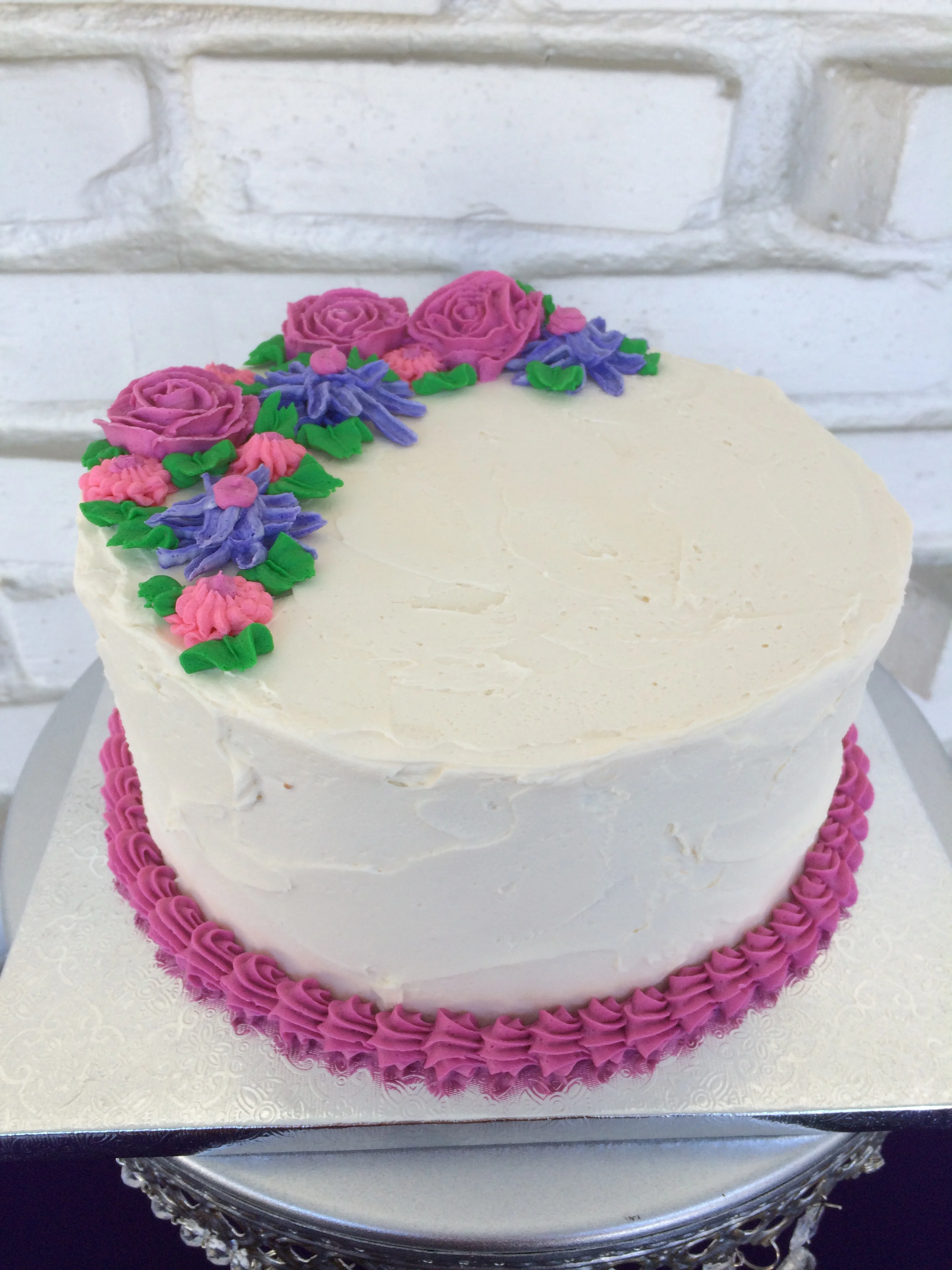 Lavender cake filled with creamed honey buttercream and adorned with buttercream flowers